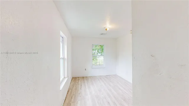a view of a room with wooden floor and a hallway