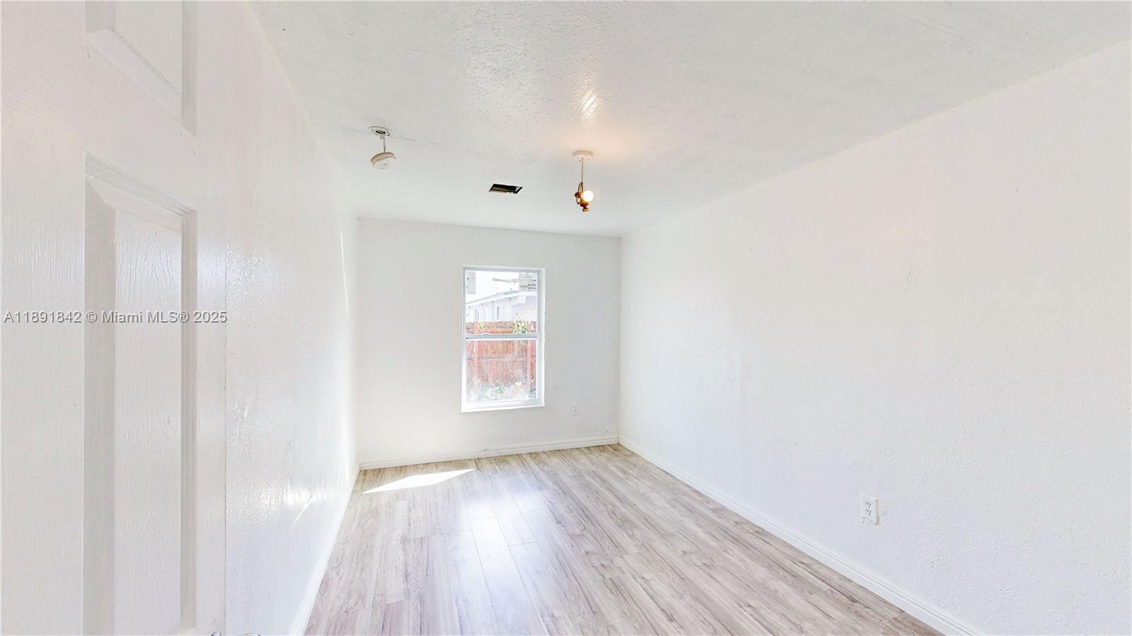 22230 Southwest 115th Court Miami, FL 33170 - Photo 32 of 63 a view of an empty room with wooden floor and a window