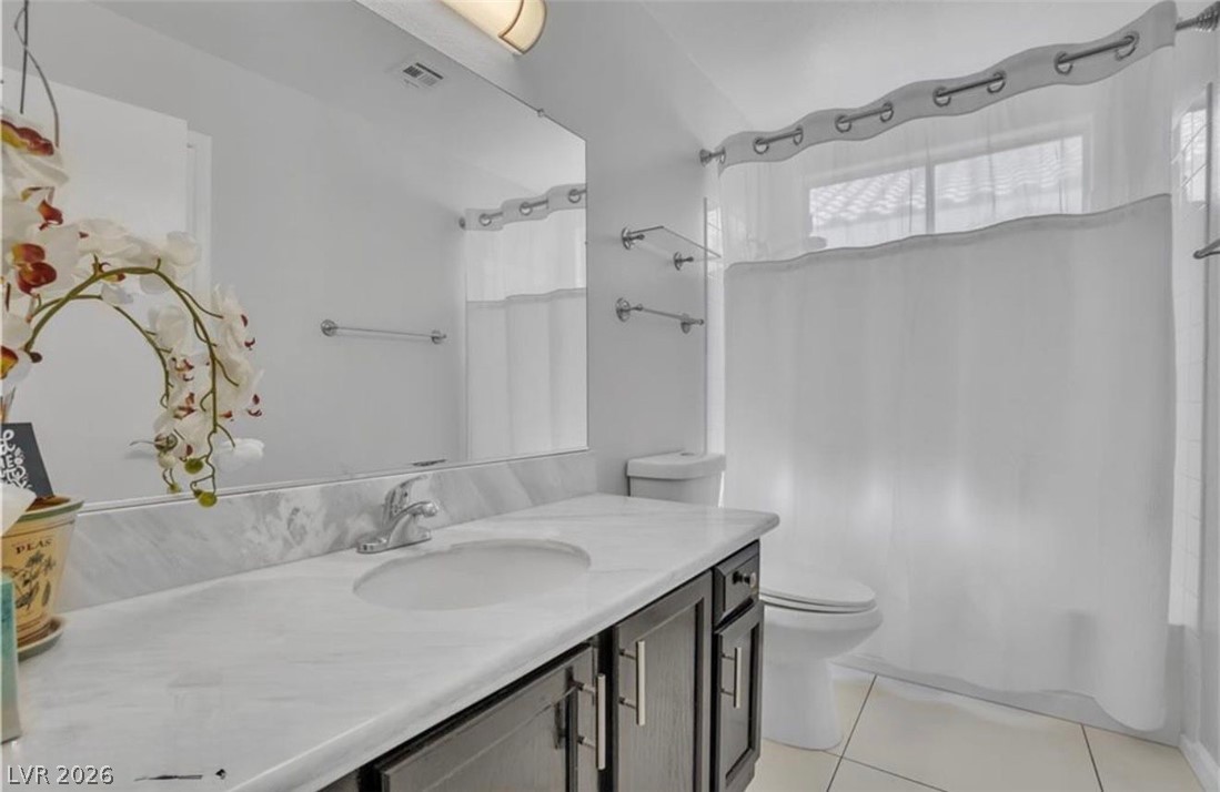 6429 Winding Ridge Las Vegas, NV 89156 - Photo 20 of 22 A well-appointed bathroom features a single vanity with a sleek countertop and practical storage below.