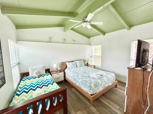 a bedroom with bed and wooden floor