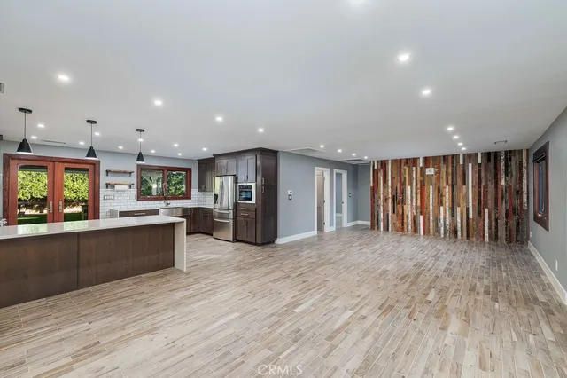 a large kitchen with stainless steel appliances granite countertop a large counter top a stove and a wooden floors