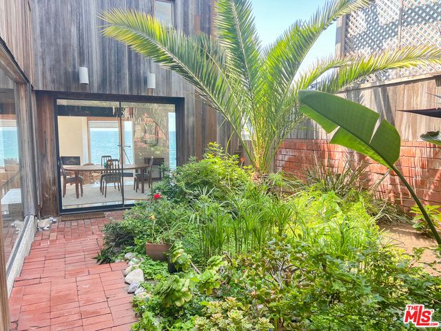 a kitchen with stainless steel appliances granite countertop a refrigerator a sink a stove and white cabinets