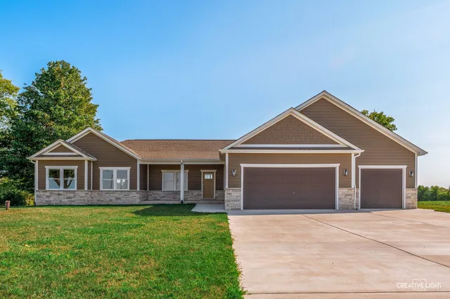 a front view of a house with a garden and yard