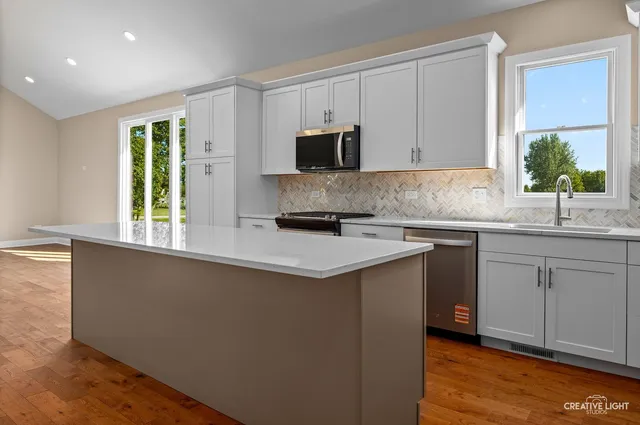 a kitchen with granite countertop a sink and a stove top oven