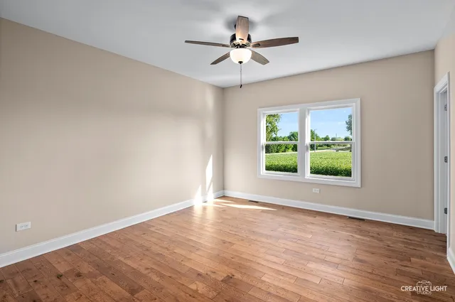 a view of room with window ceiling fan and hardwood floor
