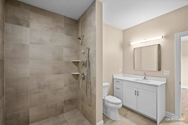 a bathroom with a toilet a sink a shower and mirror