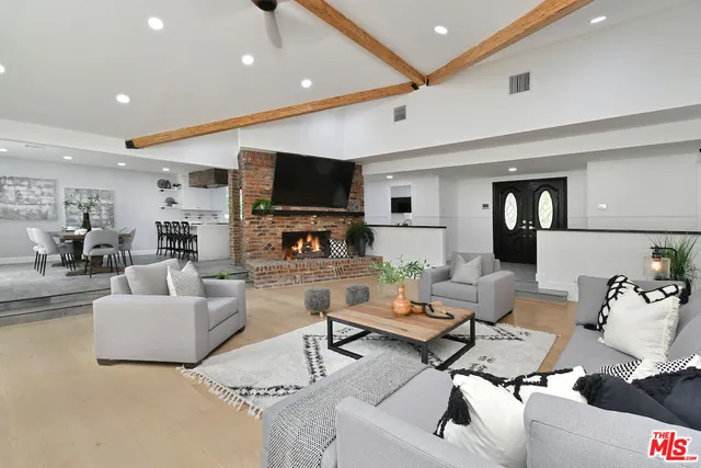 a kitchen with stainless steel appliances granite countertop a table chairs sink and cabinets