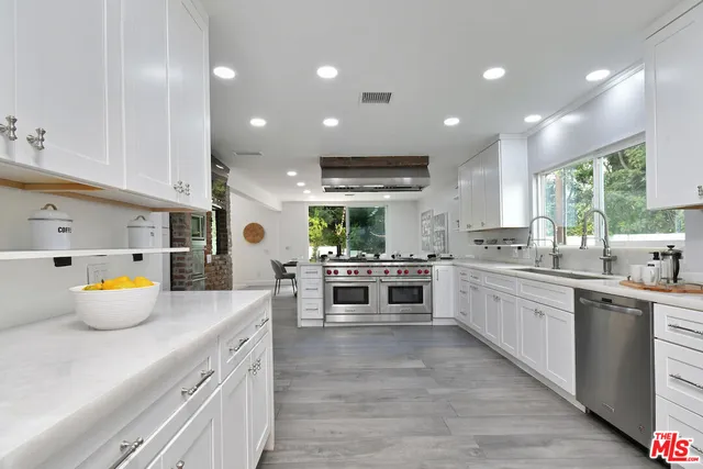 a bathroom with a granite countertop double vanity sink and mirror