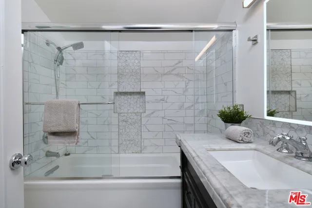 a bathroom with a granite countertop sink and a bathtub