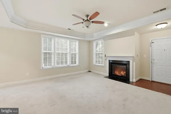 a view of an empty room with a fireplace and a window