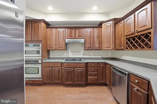 a kitchen with stainless steel appliances granite countertop a refrigerator and a stove top oven
