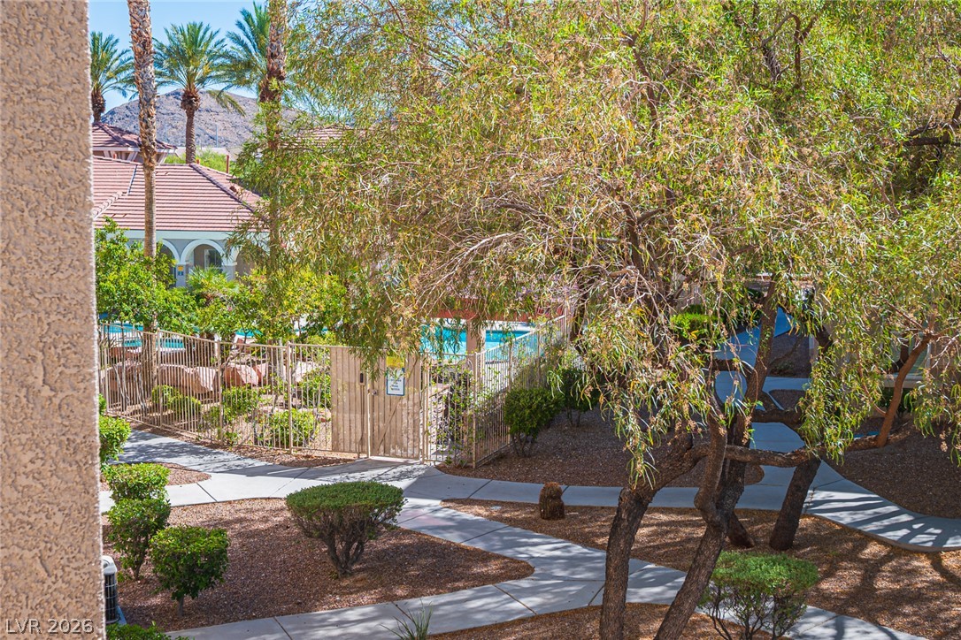 10550 West Alexander Road, Unit 2014 Las Vegas, NV 89129 - Photo 37 of 43 Lush desert landscaping and paved pathways wind through the community grounds toward the sparkling pool.