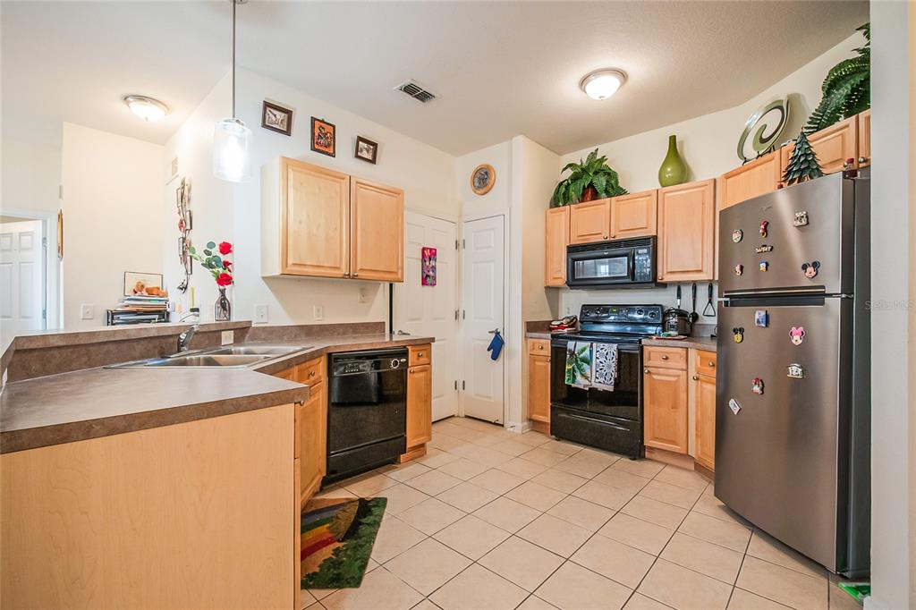 612 Terrace Ridge Circle, Unit 612 Davenport, FL 33896 - Photo 15 of 45 a kitchen with stainless steel appliances kitchen island granite countertop a refrigerator and a stove top oven