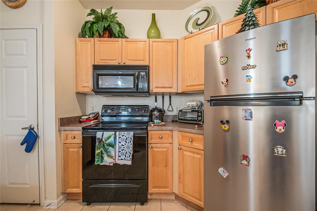 612 Terrace Ridge Circle, Unit 612 Davenport, FL 33896 - Photo 16 of 45 a kitchen with stainless steel appliances granite countertop a refrigerator and a stove