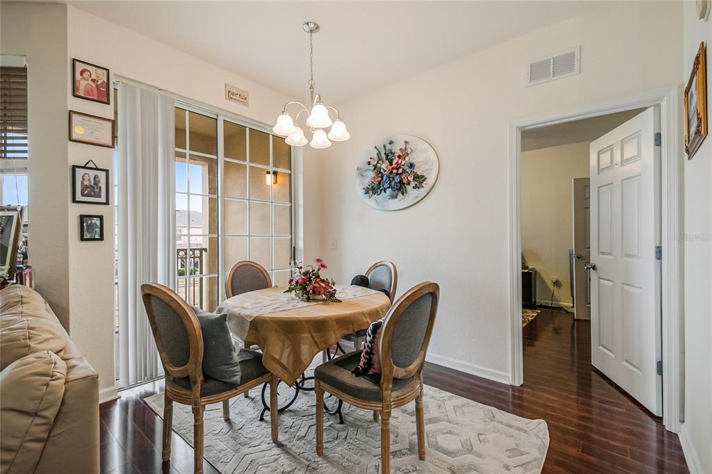 612 Terrace Ridge Circle, Unit 612 Davenport, FL 33896 - Photo 19 of 45 a view of a dining room with furniture wooden floor and a chandelier