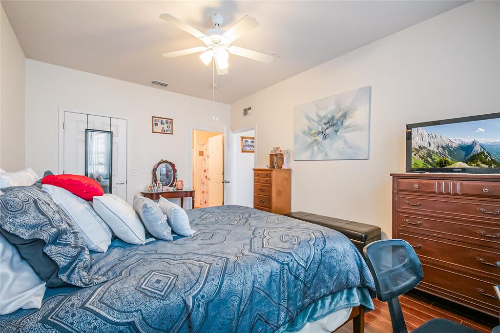 612 Terrace Ridge Circle, Unit 612 Davenport, FL 33896 - Photo 24 of 45 a bedroom with a bed and wooden floor