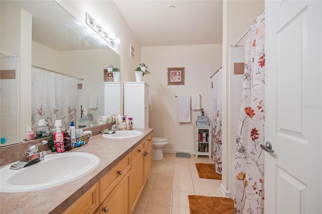 612 Terrace Ridge Circle, Unit 612 Davenport, FL 33896 - Photo 25 of 45 a bathroom with a double vanity sink mirror and shower