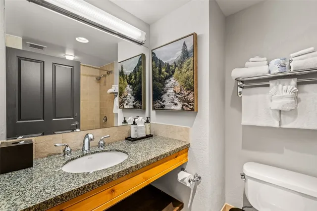 a spacious bedroom with a bed and a flat screen tv