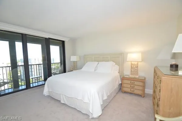 a large bed sitting in a bedroom next to a window