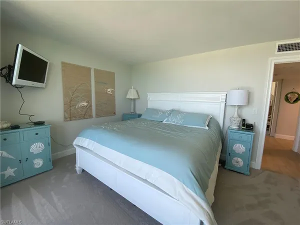 a bedroom with a bed and a tv on the dresser