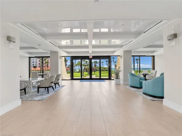 a view of a livingroom with dining area a kitchen view and wooden floor