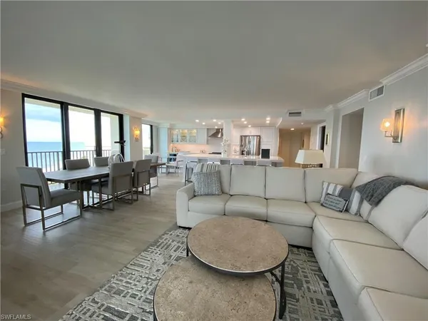 a living room with furniture and floor to ceiling windows