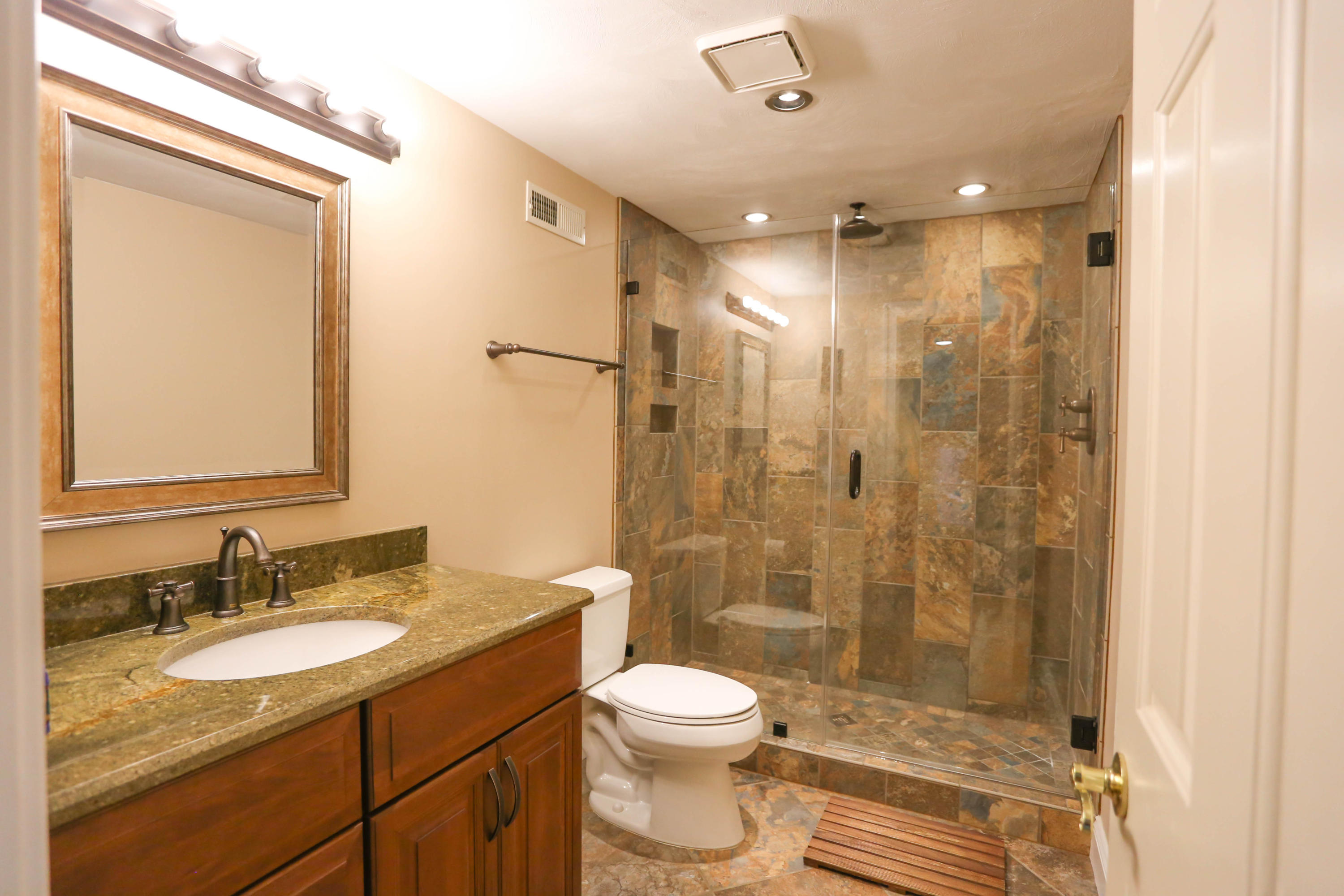 6715 Fairway Ridge Road Roanoke, VA 24018 - Photo 28 of 35 a bathroom with a granite countertop sink toilet a shower and a mirror