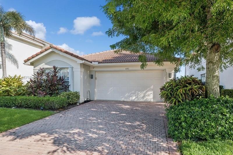 8911 Chestnut Ridge Way Boynton Beach, FL 33473 - Photo 1 of 20 a front view of a house with a yard and a garage