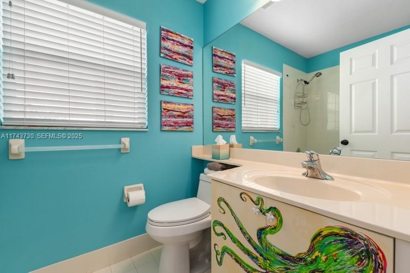 8911 Chestnut Ridge Way Boynton Beach, FL 33473 - Photo 16 of 20 a bathroom with a sink a toilet and a mirror
