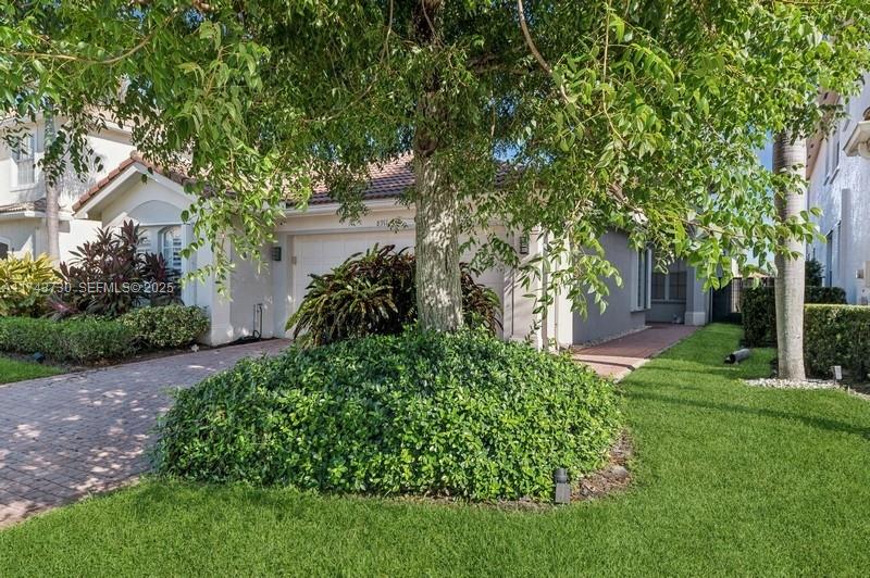 8911 Chestnut Ridge Way Boynton Beach, FL 33473 - Photo 2 of 20 a view of a garden with large trees