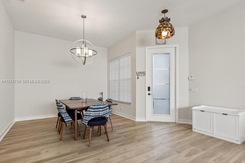 8911 Chestnut Ridge Way Boynton Beach, FL 33473 - Photo 3 of 20 a view of a dining room with furniture and wooden floor