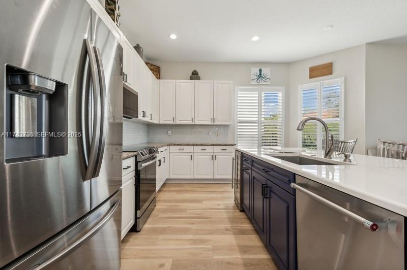 8911 Chestnut Ridge Way Boynton Beach, FL 33473 - Photo 7 of 20 a kitchen with stainless steel appliances granite countertop a sink stove and refrigerator