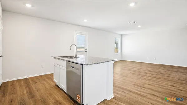 a kitchen with a sink and wooden floor