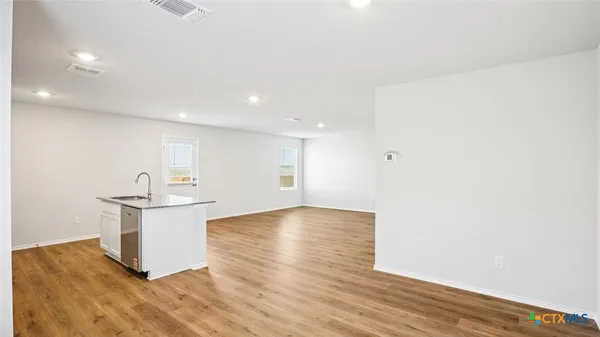 a view of a kitchen with wooden floor and stainless steel appliances