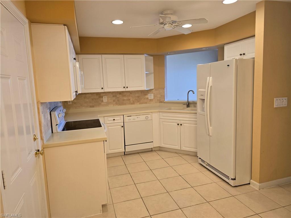 25069 Peacock Lane, Unit 101 Naples, FL 34114 - Photo 12 of 49 a kitchen with a refrigerator sink stove and cabinets
