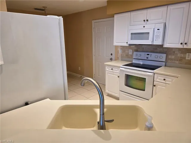 a front view of a house with a yard and potted plants