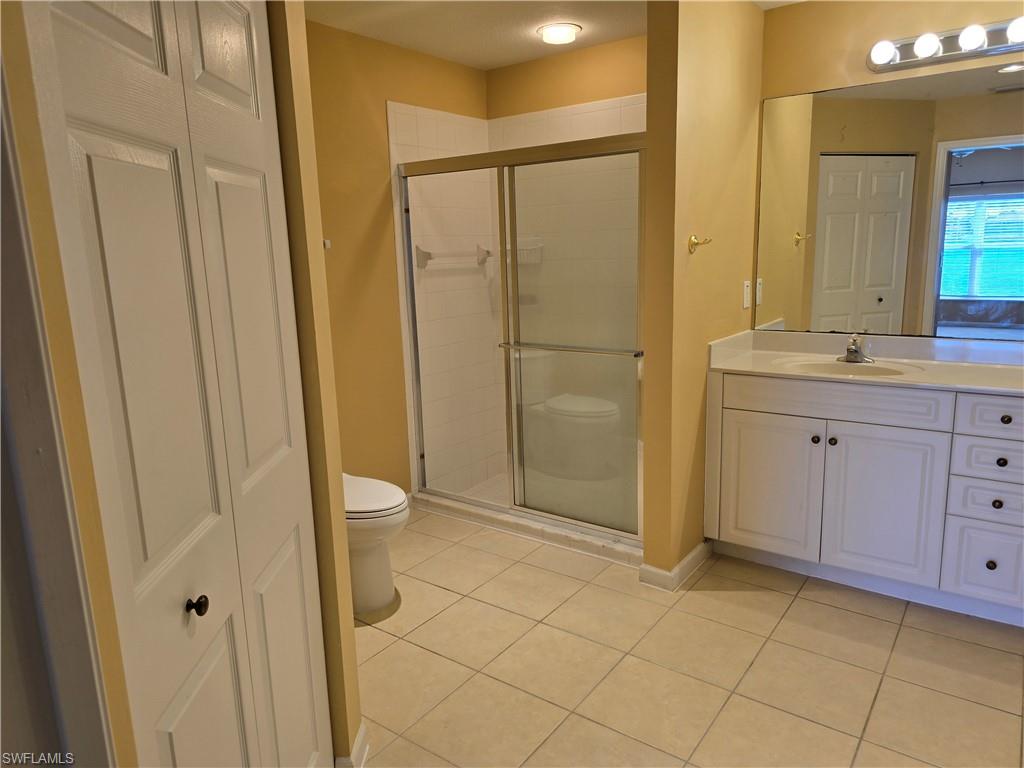 25069 Peacock Lane, Unit 101 Naples, FL 34114 - Photo 26 of 49 a bathroom with a granite countertop sink a toilet and a mirror