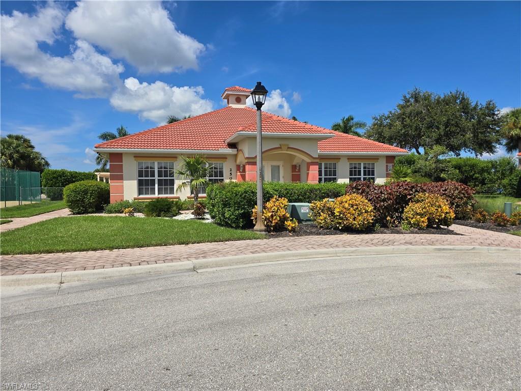 25069 Peacock Lane, Unit 101 Naples, FL 34114 - Photo 31 of 49 a front view of a house with a yard and potted plants