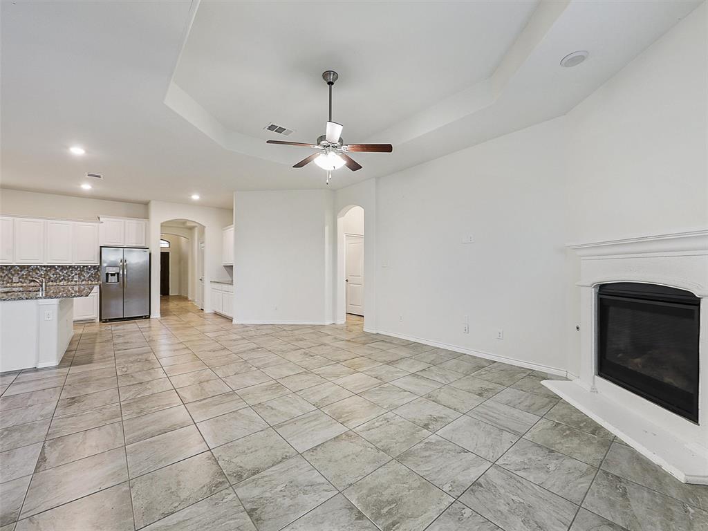 421 Maverick Street Anna, TX 75409 - Photo 12 of 25 Unfurnished living room featuring a ceiling fan, a glass covered fireplace, arched walkways, and recessed lighting