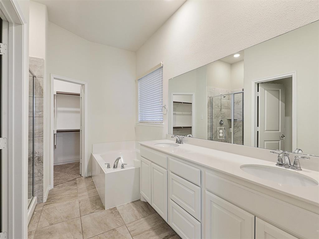 421 Maverick Street Anna, TX 75409 - Photo 15 of 25 Full bath featuring a walk in closet, a stall shower, double vanity, and a bath