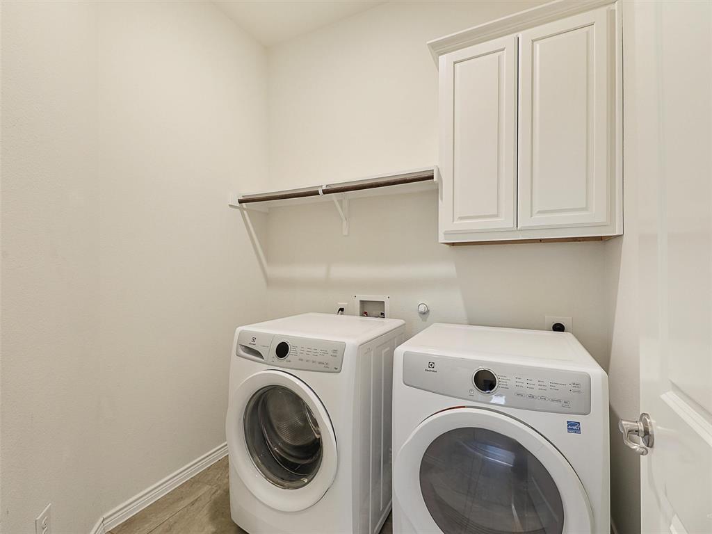 421 Maverick Street Anna, TX 75409 - Photo 22 of 25 Laundry area featuring washer and clothes dryer, cabinet space, and light wood-type flooring