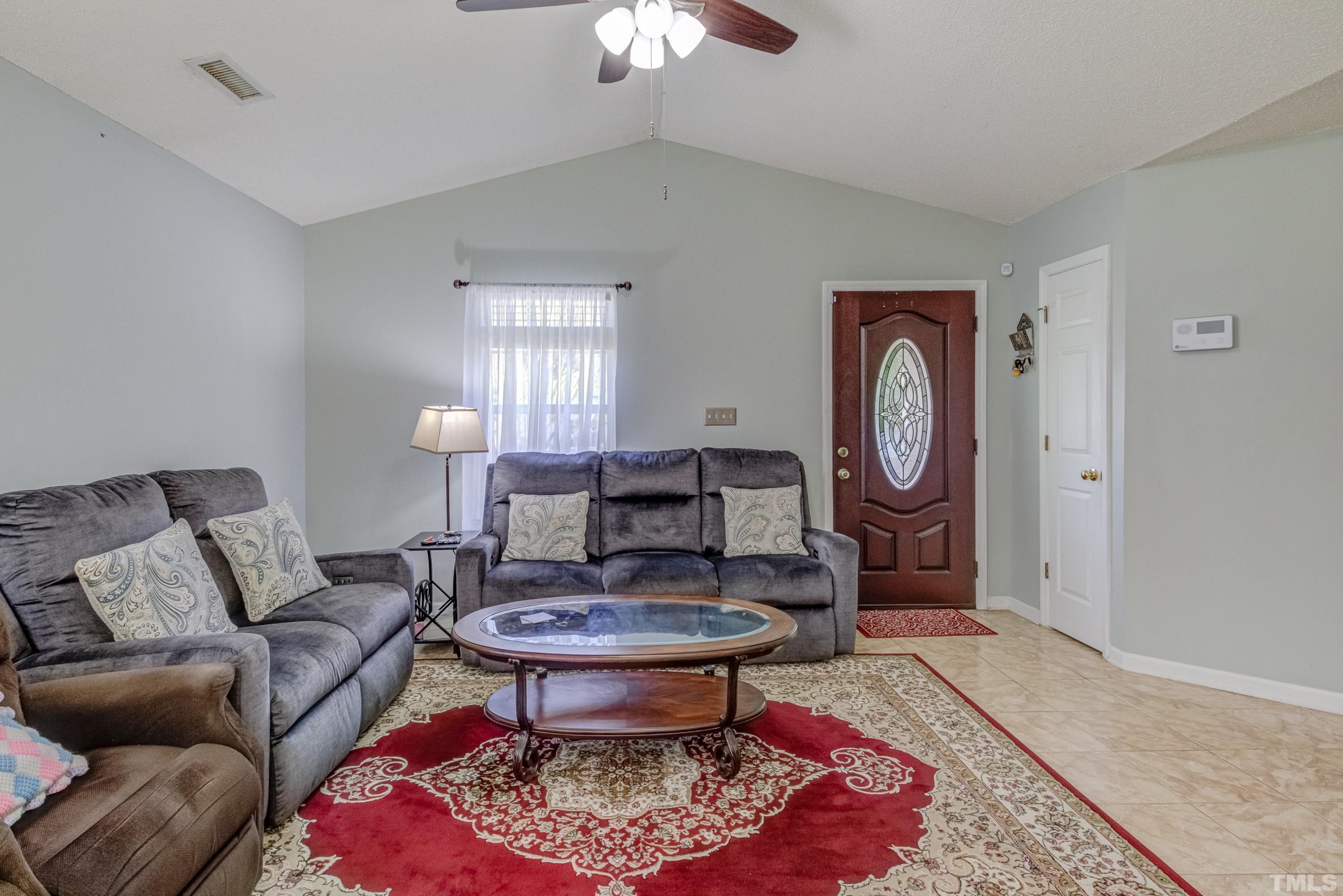 4917 Silverdene Street Raleigh, NC 27616 - Photo 11 of 37 a living room with furniture a rug a lamp and a rug