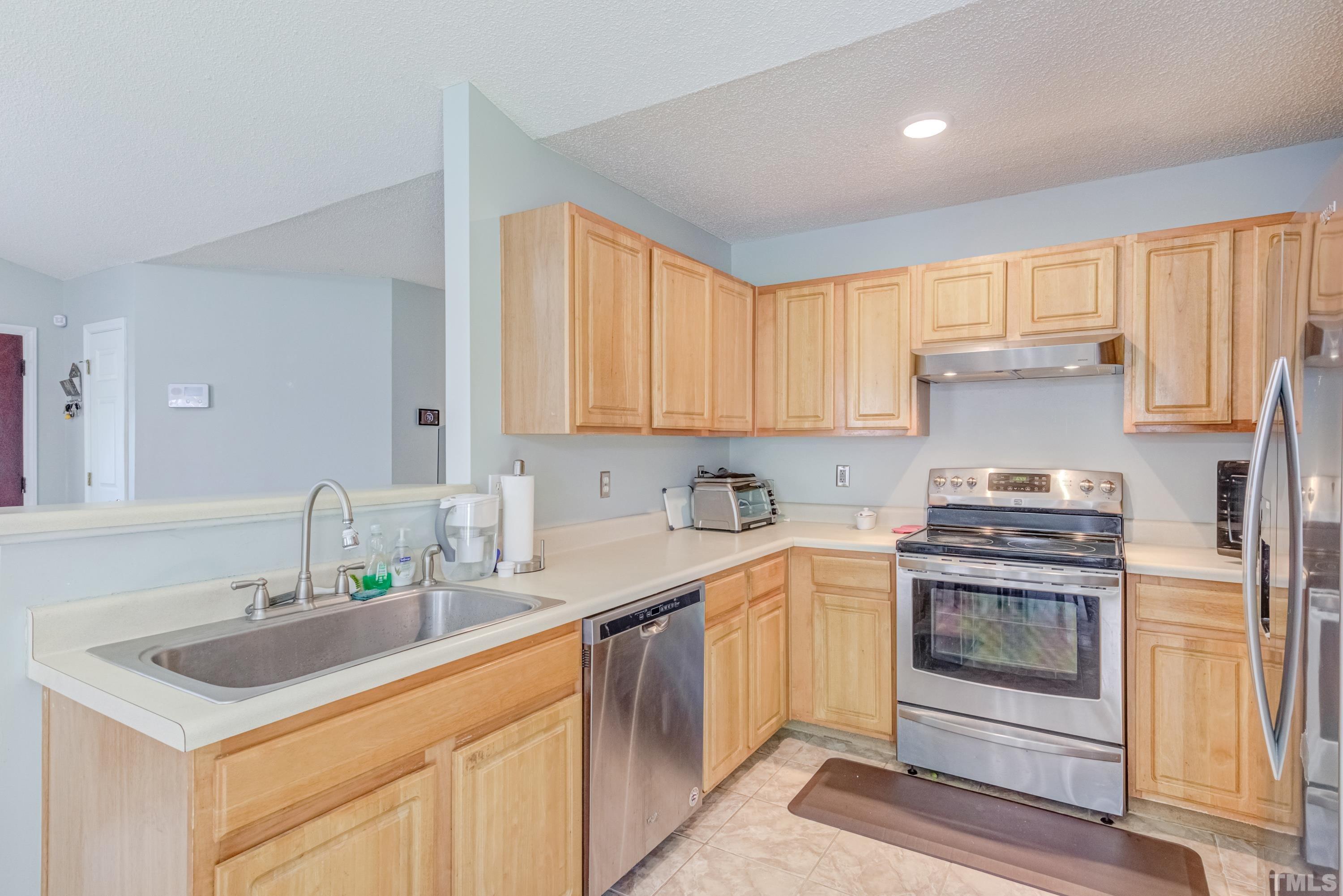 4917 Silverdene Street Raleigh, NC 27616 - Photo 16 of 37 a kitchen with a sink stove and cabinets