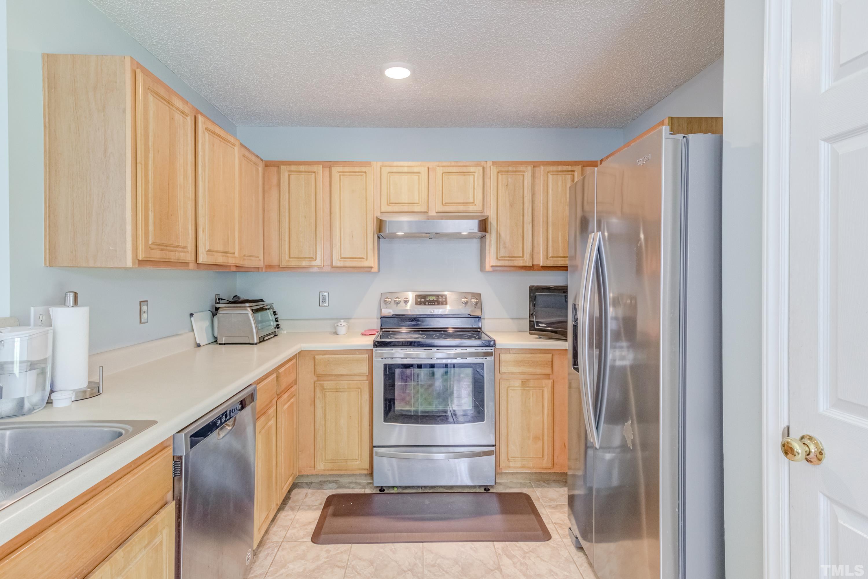 4917 Silverdene Street Raleigh, NC 27616 - Photo 17 of 37 a kitchen with a stove a refrigerator and a sink