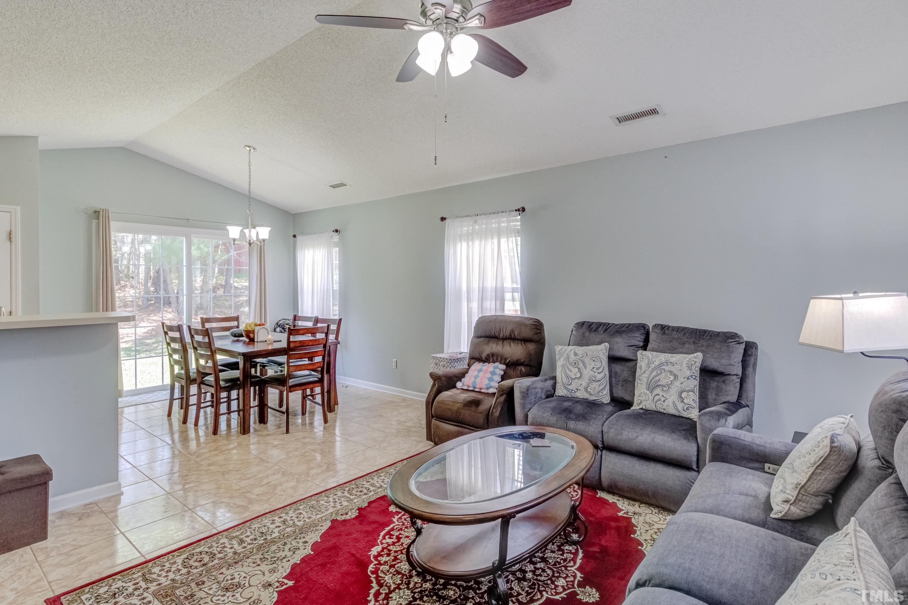 4917 Silverdene Street Raleigh, NC 27616 - Photo 9 of 37 a living room with furniture a dining table and a chandelier