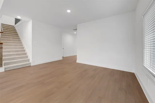 a view of an empty room with a chandelier fan