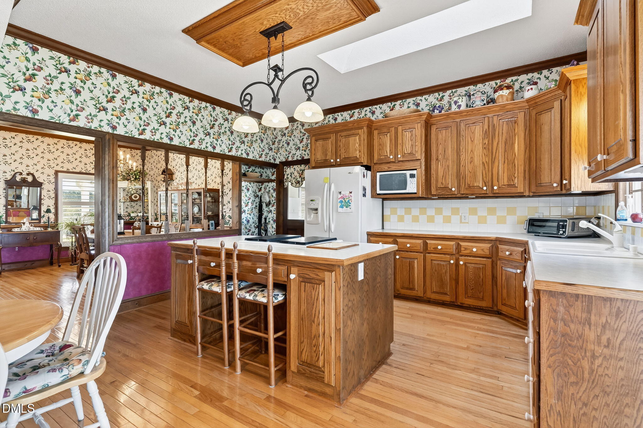 1190 Sanders Road Benson, NC 27504 - Photo 39 of 96 a kitchen with stainless steel appliances kitchen island granite countertop a table chairs and a wooden cabinets
