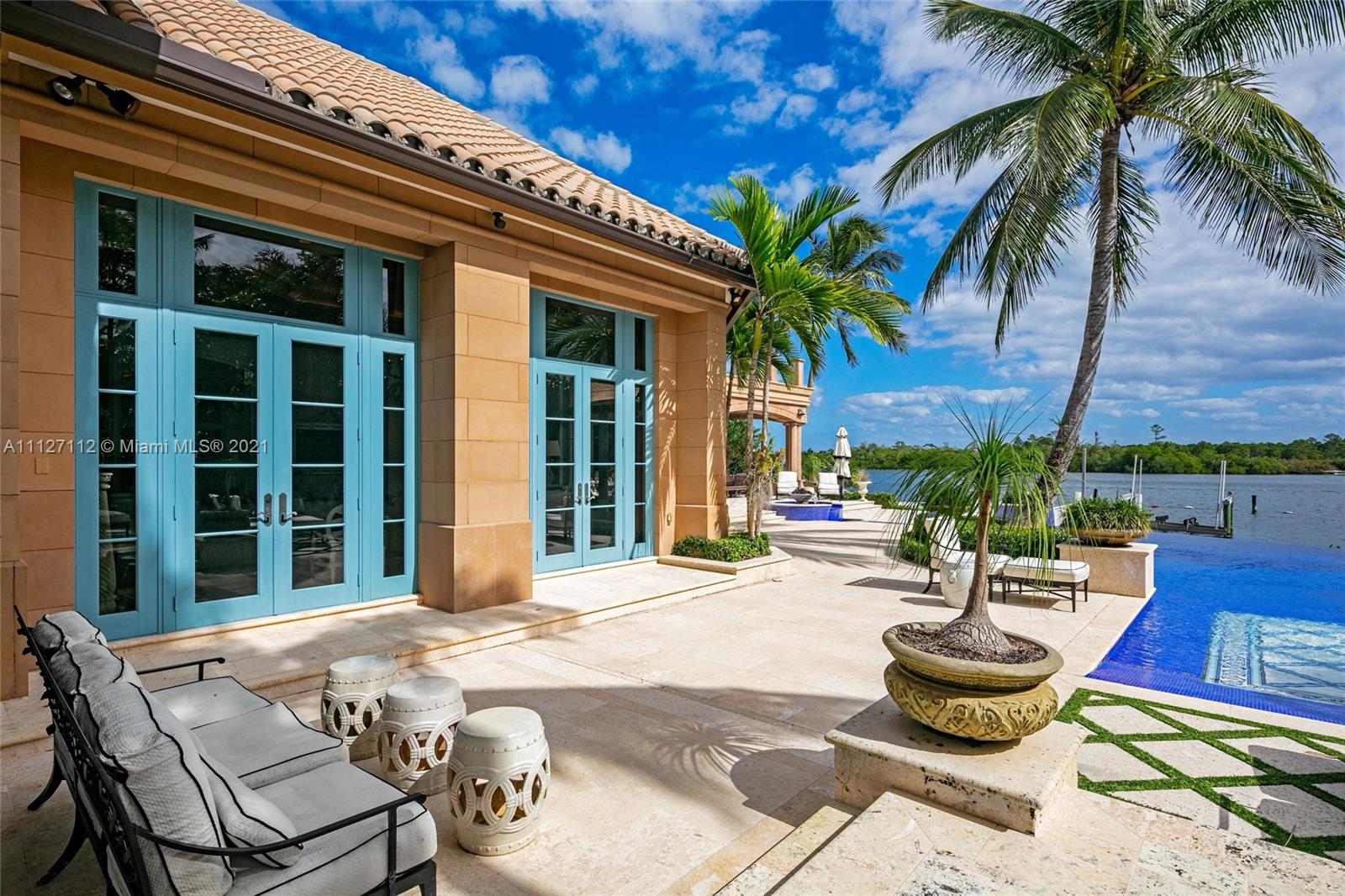 372 Regatta Drive Jupiter, FL 33477 - Photo 84 of 93 a view of a backyard with table and chairs potted plants and palm tree