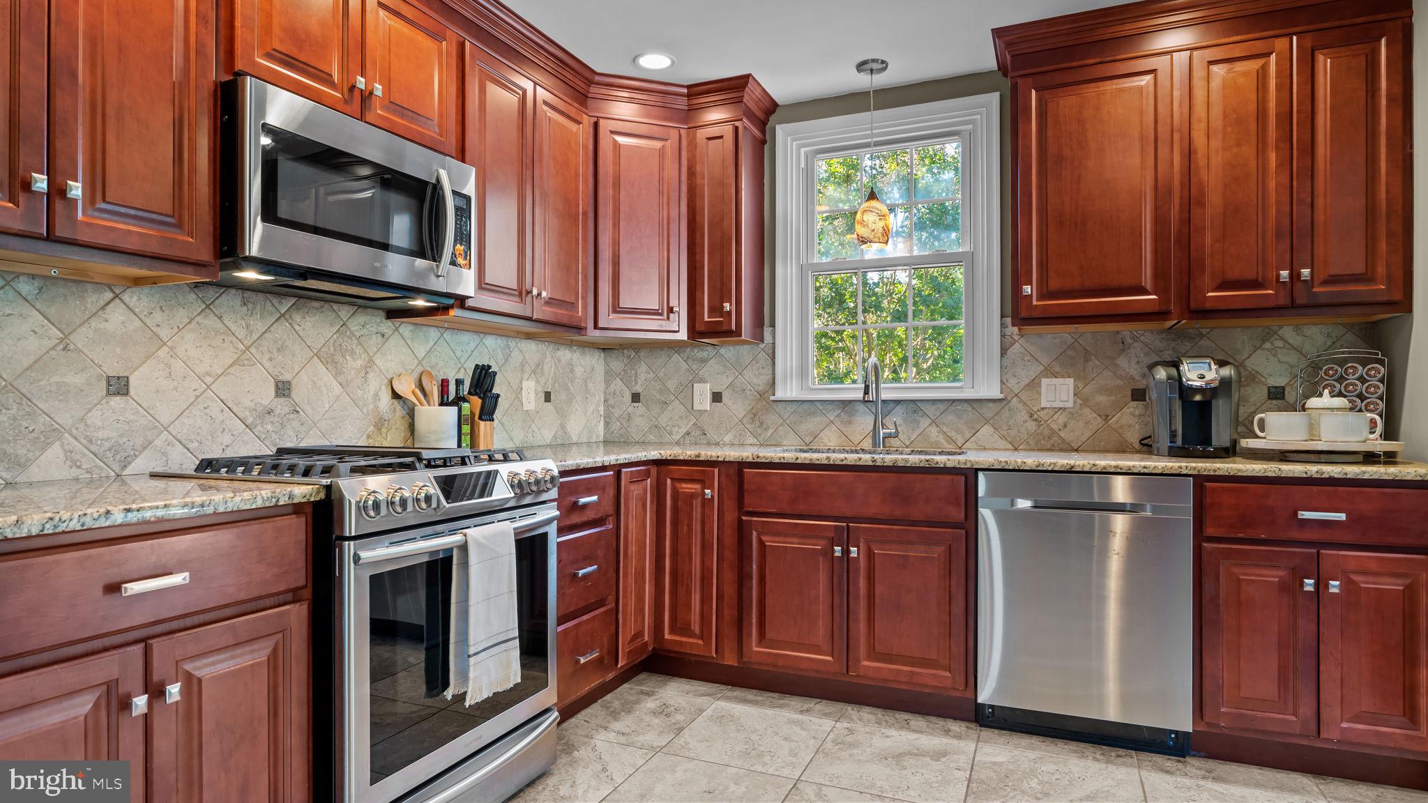 1002 Windsor Road Warminster, PA 18974 - Photo 16 of 57 a kitchen with stainless steel appliances granite countertop wooden cabinets stove top oven and sink