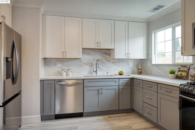 a kitchen with cabinets appliances a sink and a window